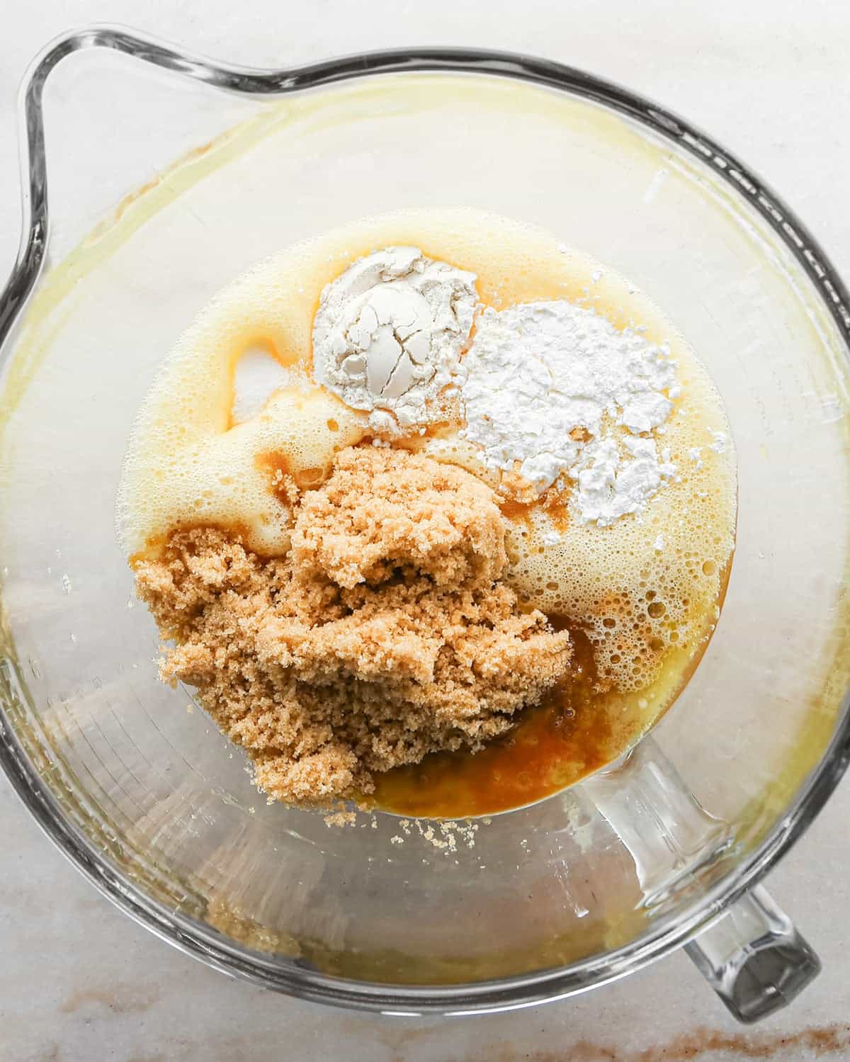 how to make pecan pie without corn syrup - brown sugar, honey, melted butter, flour and cornstarch added to the beaten egg mixture in a glass mixing bowl before being mixed together