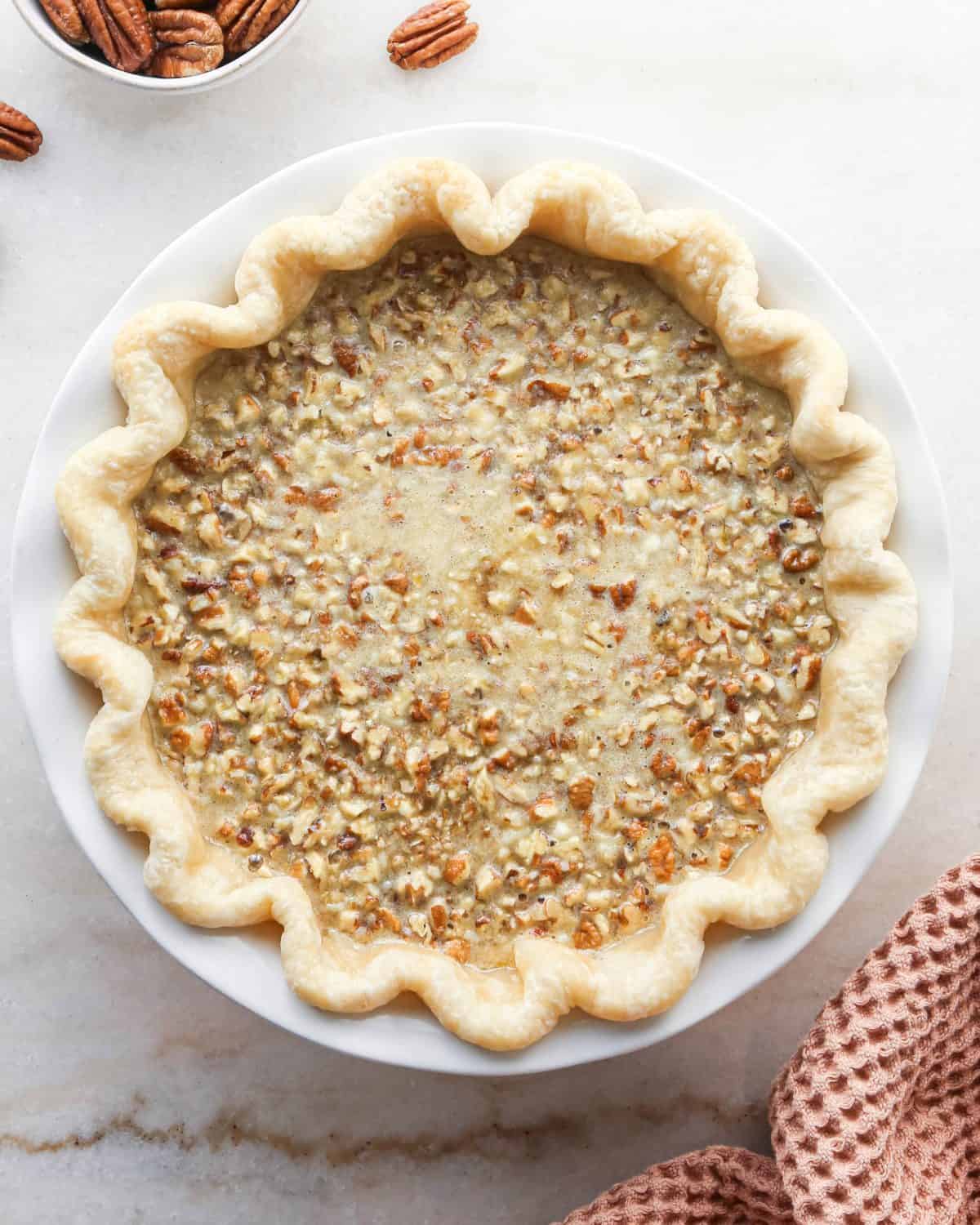 how to make pecan pie without corn syrup - filling settled in a white ceramic baking dish