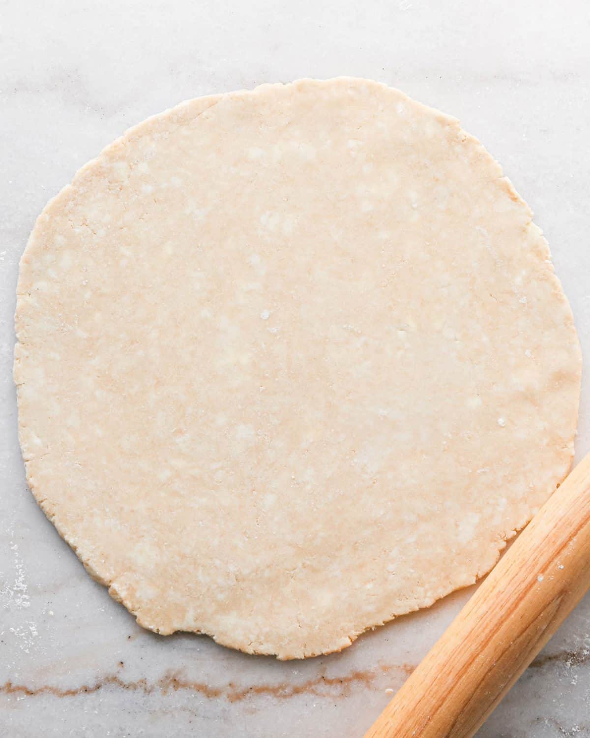 how to make pecan pie without corn syrup - pecan pie crust rolled into a circle on a marble surface